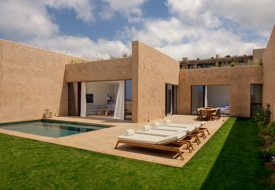 a pool and lounge chairs in a house