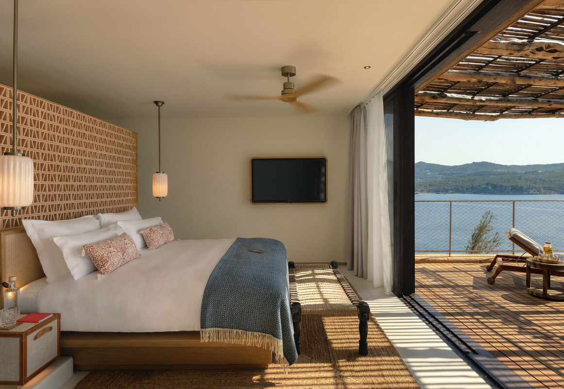 a bedroom with a television and a view of the water