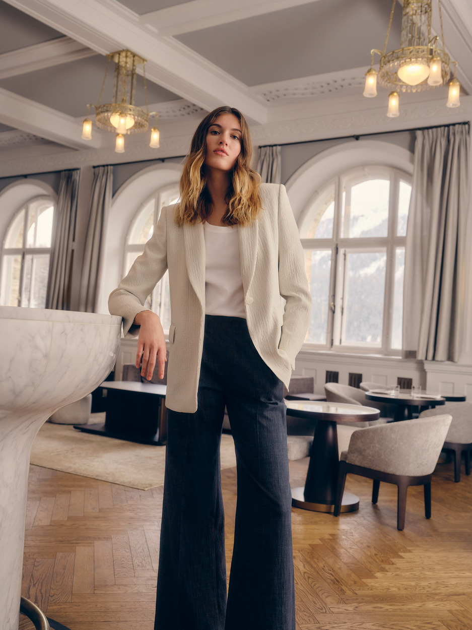 a woman in a suit standing next to a bar