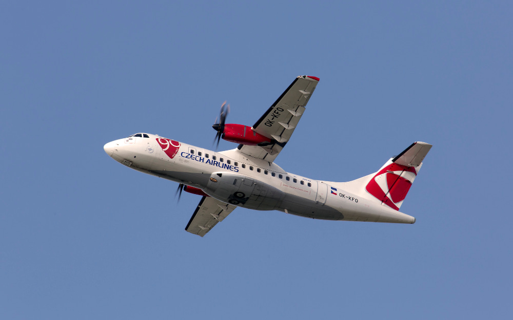 El avión en el aire visto desde abajo a la izquierda recortado contra el cielo azul