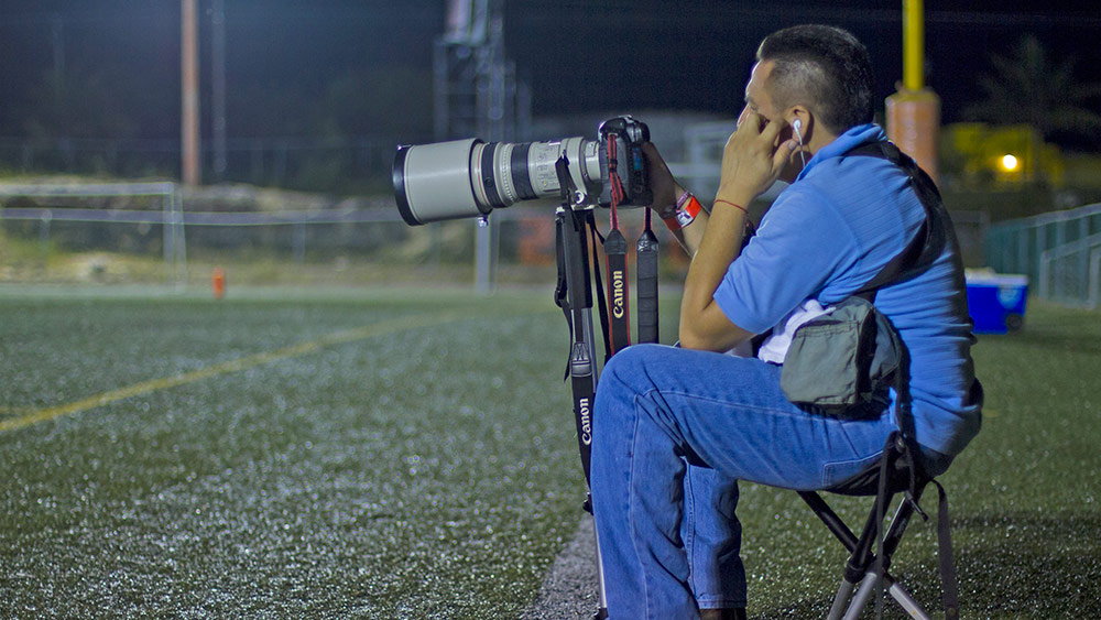 Un fotógrafo sentado en un taburete Walkstool