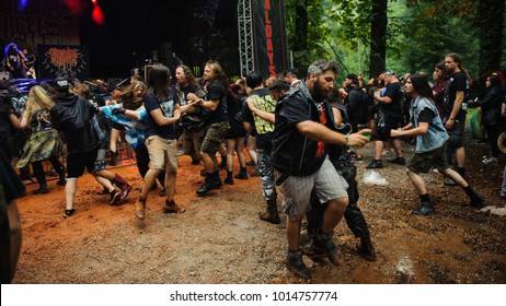 Fans en un mosh pit durante un concierto de heavy metal, mostrando energía y camaradería